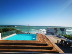 a swimming pool with a view of the ocean at Seaside apartment - Big Bay beach in Cape Town