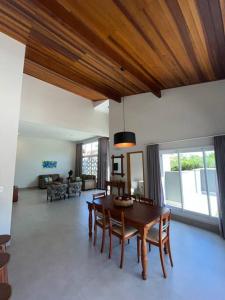 ein Wohnzimmer mit einem Holztisch und Stühlen in der Unterkunft Casa Mero no Residencial Mar Verde em Caraguatatuba in Caraguatatuba