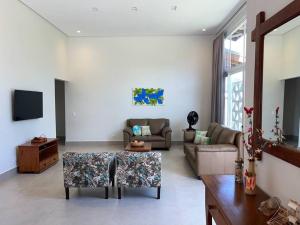 ein Wohnzimmer mit Sofa und Tisch in der Unterkunft Casa Mero no Residencial Mar Verde em Caraguatatuba in Caraguatatuba