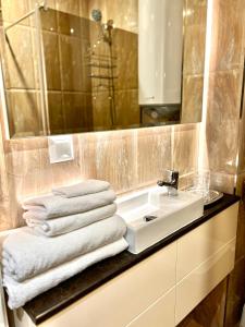 a bathroom with a sink and towels on a counter at Horizon Apartament Gut in Sveti Vlas