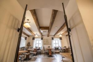 a dining room with tables and chairs and windows at Zajazd Biskupi in Racibórz