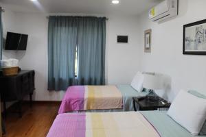a hotel room with two beds and a window at CAJOMA Villa in San Ignacio