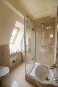 een badkamer met een douche, een wastafel en een toilet bij Zajazd Biskupi in Racibórz