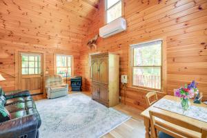 a living room with a couch and a table in a cabin at Quaint Cabin with Stream in Blue Ridge! in Sparta