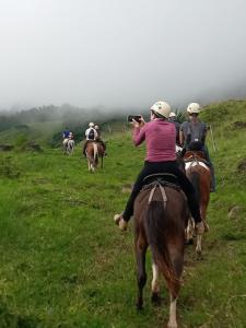 a group of people riding horses in a field at Casa Morella in Monteverde Costa Rica