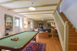 een woonkamer met een pooltafel en een trap bij Heather Cottage in Penzance