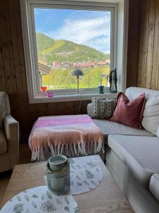 a living room with a large window and a couch at Sentral leilighet på Geilo in Geilo