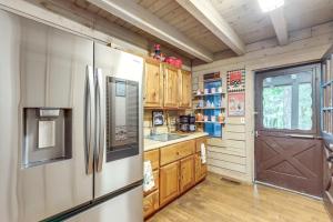 Una cocina con refrigerador de acero inoxidable y gabinetes de madera. en Ellijay Getaway Fire Pit and Hot Tub, en Ellijay