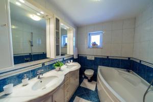 a bathroom with two sinks and a tub and a toilet at Apartman Nada in Zmijavci