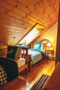 a bedroom with two beds in a room with wooden ceilings at Green Mountain base camp for year-round adventure! in Londonderry +33 photos