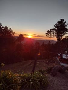 a sunset on a hill with the sun setting at Cabaña la Escondida in Cruz de Madroño +11 photos