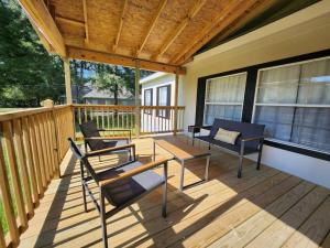 a screened porch with chairs and tables on a deck at Thomas House in Hammond