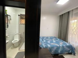 キガリにあるCamden Homeのベッドのある寝室とトイレのある浴室 +10枚の写真