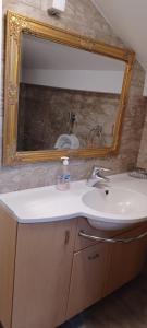 a bathroom with a sink and a mirror at Vikendica Sofia in Žagubica +7 photos