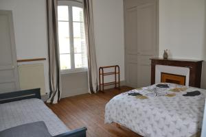 una camera bianca con letto e camino di La ferme aux Hirondelles, proche Giverny a Fontaine-sous-Jouy
