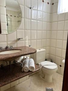 a bathroom with a toilet and a sink and a mirror at Crystal Plaza Hotel Marista in Goiânia