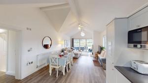 a kitchen and living room with a table and chairs at Prospect Lodge at The Bay Filey, sleeps up to 6, and 2 dogs stay for free! in Filey