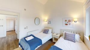 a bedroom with two beds and a mirror at Prospect Lodge at The Bay Filey, sleeps up to 6, and 2 dogs stay for free! in Filey +28 photos
