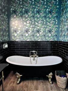 a bath tub in a bathroom with a floral wallpaper at The Retreat at Fredricksburg in Fredericksburg