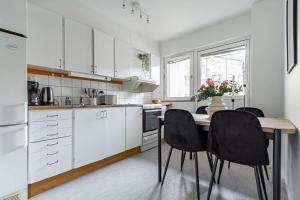a kitchen with a wooden table and black chairs at Budget-friendly studio on Södermalm, construction work in Stockholm