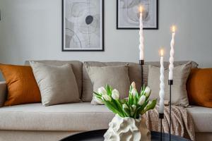 a living room with a couch with two candles on a table at Budget-friendly studio on Södermalm, construction work in Stockholm