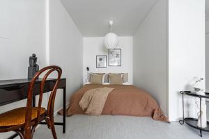 a bedroom with a bed with a desk and a chair at Budget-friendly studio on Södermalm, construction work in Stockholm