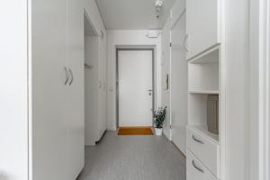 a hallway with white cabinets and a door with a television at Budget-friendly studio on Södermalm, construction work in Stockholm