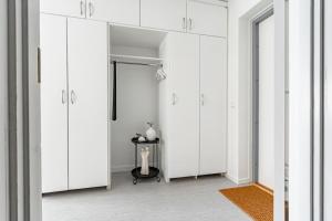 a white closet with white cabinets and a table at Budget-friendly studio on Södermalm, construction work in Stockholm