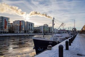 a boat is docked at a dock in a city at Budget-friendly studio on Södermalm, construction work in Stockholm