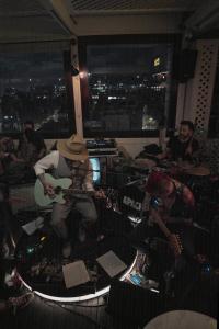 a group of people sitting in a room playing guitar at The Click Clack Hotel Bogotá in Bogotá