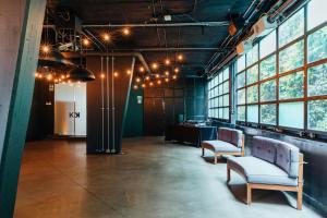 a room with two chairs and a table and windows at The Click Clack Hotel Bogotá in Bogotá