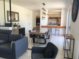 un salon et une cuisine avec une table et des chaises dans l'établissement Villa Kerleven- 150m plage - Spa intérieur-piscine, à La Forêt-Fouesnant