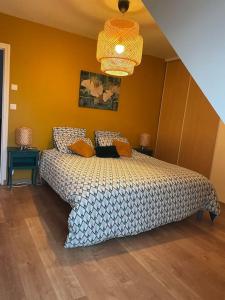 une chambre avec un lit et un lustre dans l'établissement Villa Kerleven- 150m plage - Spa intérieur-piscine, à La Forêt-Fouesnant 35 autres photos