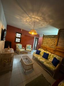 a living room with a couch and chairs at Hostel Casa Jambo Guaruja in Guarujá