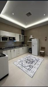 a kitchen with white cabinets and a rug on the floor at شقه فاخره بجوار الراشد مول in Sīdī Ḩamzah