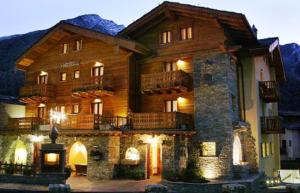 un grande edificio in legno con balcone in cima di Hotel Maison Saint Jean a Courmayeur