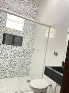 a white bathroom with a shower and a toilet at Vista da Serra, Casa Térrea e Superior, entradas independentes in Cavalcante +27 photos
