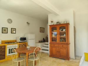 a kitchen with a table and a wooden cabinet at Appartement Les Tilleuls in Olmi-Cappella