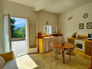 a living room with a table and a kitchen at Appartement Les Tilleuls in Olmi-Cappella