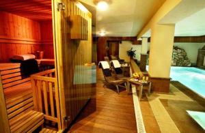 a room with a swimming pool and a living room at Hotel Maison Saint Jean in Courmayeur