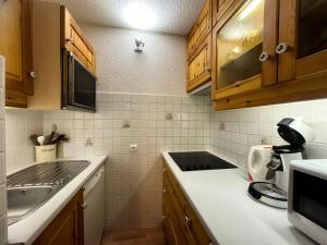 a kitchen with wooden cabinets and a counter top at Résidence Carroley B - Appartement fonctionnel · Proche des pistes · Vue pistes MAE-4104 in Mâcot La Plagne