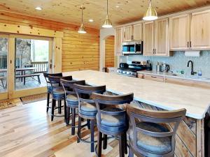 a kitchen with a large island with bar stools at Fortune Mountain Retreat in McHenry +35 photos