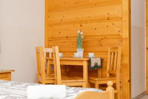 a room with a table and chairs and a wooden wall at Chata Góralska u Kotelnickich in Olcza
