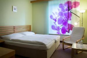 sypialnia z łóżkiem i oknem z malowidłem kwiatowym w obiekcie Penzion U Zámecké Zahrady w mieście Lipník nad Bečvou +34 zdjęcia