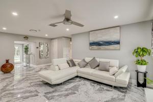 a living room with a couch and a ceiling fan at Pet-Friendly Gem with Pool and Yard in West Palm Beach in West Palm Beach
