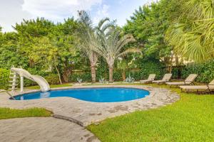 a swimming pool with a slide in a yard at Pet-Friendly Gem with Pool and Yard in West Palm Beach in West Palm Beach