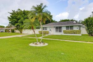 a palm tree in a yard in front of a house at Pet-Friendly Gem with Pool and Yard in West Palm Beach in West Palm Beach