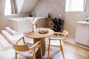 une salle à manger avec une table et deux chaises dans l'établissement Eden Room - Luxe, Balnéo & Sauna, au Mans