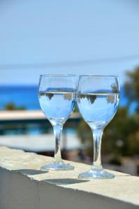 two wine glasses sitting on a ledge with water in them at Studios Kahlua in Agios Prokopios