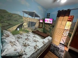 ein Schlafzimmer mit einem Bett und einem Gemälde an der Wand in der Unterkunft Casa Do Guh in São Thomé das Letras